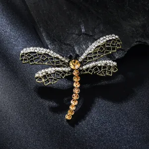 Dettaglio macro della spilla libellule di lusso con diamanti e cristalli ambrati lucenti
