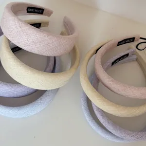 Close-up of assorted pastel padded headbands with textured fabric and handmade labels