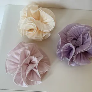 Oversized pearlescent pleated satin scrunchies in cream, pink, and lavender colors