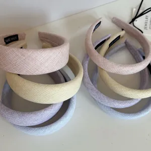 Detailed view of pastel padded headbands in cream pink, yellow, and lavender colors.