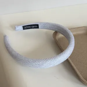 Close-up of light blue padded headband with textured fabric and Hand Made label