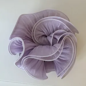 Close-up detail of a large light purple pearlescent pleated satin hair scrunchie