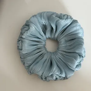 Top-down view showing the shimmering texture of a light blue pleated large scrunchie