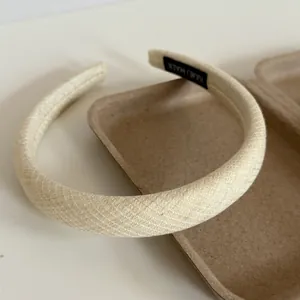 Macro detail of a cream-colored wide padded headband showing soft woven texture