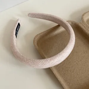 Detail showing the cream-colored fabric and textured finish of the padded headband
