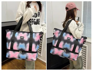 Detail of expandable travel bag with pink and blue chevron pattern shown on model