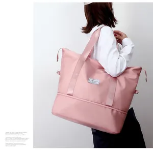 Close-up detail of a large pink waterproof travel bag with separate bottom storage area