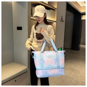 Stylish light blue and pink gradient expandable travel bag held by a model indoors.