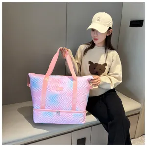 Close-up detail of the pink and blue gradient quilted travel bag shown in use by a model