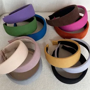 Close-up of assorted colorful ribbed fabric sponge headbands displayed on a textured white background