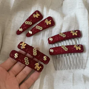 Detailopname van rode strass haarklemmen en kammen met gouden paardenbedeltjes