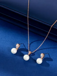 Detailopname van elegante parel sieradenset met roségouden zirkonia ketting en oorbellen