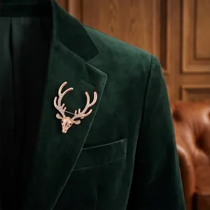 Elegant rose gold deer head brooch with sparkling crystals on dark green velvet suit