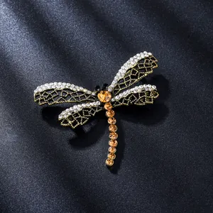 Elegante spilla a libellula dorata con strass bianchi e ambrati scintillanti di lusso