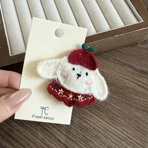 Nahaufnahme einer rot bestickten Welpen-Haarspange mit feinem Blumenmuster-Details