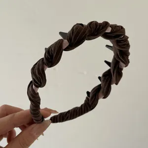 Detail view of brown twisted striped headband with non-slip internal teeth for secure fit
