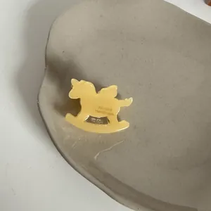 Détail macro d'une petite pince à cheveux en acétate en forme de cheval à bascule
