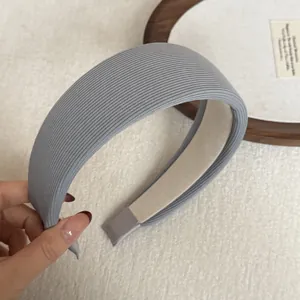 Detail shot of a light grey wide padded headband featuring soft ribbed fabric texture.