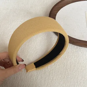 Close-up detail of a yellow ribbed fabric wide headband with soft sponge padding