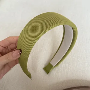 Detailed close-up of a green ribbed fabric wide sponge padded headband with soft texture