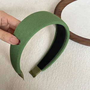Detail of soft green ribbed fabric wide sponge headband showing texture and thickness