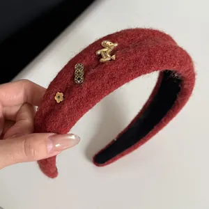Detailaufnahme eines roten Plüschstirnbands mit goldenen Pferde-Anhängern