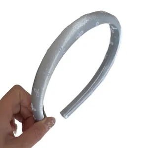 Elegant silver satin padded headband featuring delicate white bow patterns for women hair