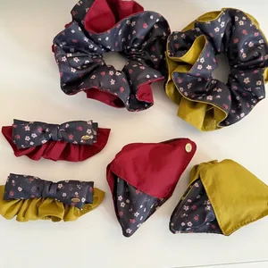 Detail of vintage floral hair scrunchies and bow clips set in red and yellow.