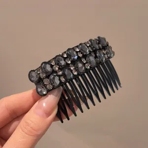Close-up detail of an elegant black hair comb adorned with shimmering dark grey rhinestones.