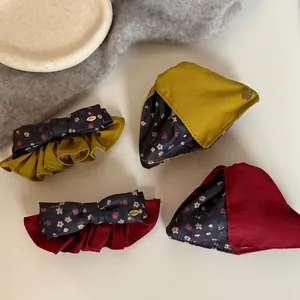 Detailed view of vintage floral print hair clips and matching scrunchies in various colors