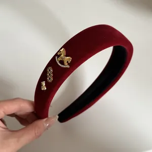 Détail en gros plan d'un serre-tête en velours rouge avec cheval à bascule et strass