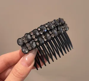 Close-up of elegant black hair comb with sparkling grey rhinestones for hairstyles