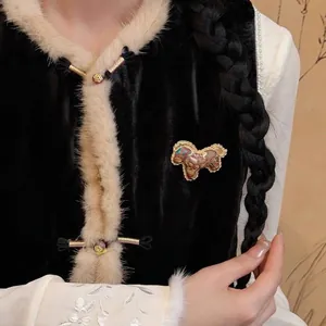 Detail shot of a handmade Song brocade pony brooch on an elegant black velvet vest.