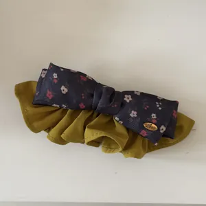 Detailed view of retro floral bow hair scrunchie in olive green and navy blue colors
