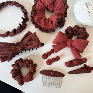 Detailed view of burgundy striped and heart-themed hair accessories set with scrunchies
