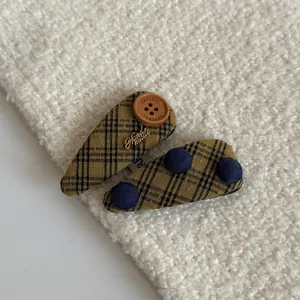 Close-up of vintage mustard plaid hair clips with wooden buttons and blue accents