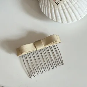 Elegant champagne satin bow hair comb with sturdy metal teeth shown in detail view