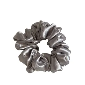 Elegante zilveren satijnen scrunchie versierd met fonkelende kleine strassteentjes.