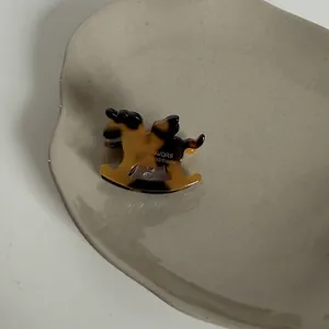 Vue détaillée d'une pince à cheveux en acétate écaille de tortue en forme de cheval à bascule.
