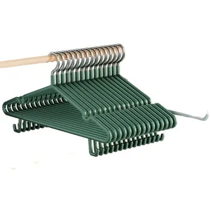 Set of wide non-slip clothes hangers in forest green on a wooden rod.