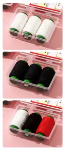 Detail of portable sewing kit featuring white, black, and red thread in clear boxes.