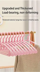 Detailed macro shot of thickened pink non-slip seamless hangers hanging on a wooden clothes rail.