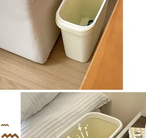 Vista de detalle de un cubo de basura delgado crema en un hogar de estilo mínimo