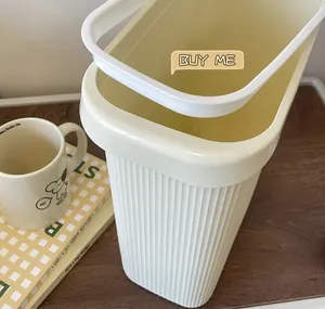 Detalle de cerca de un cubo de basura color crema minimalista con anillo de revestimiento blanco