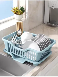 Blue plastic dish drying rack with drain tray shown on a kitchen countertop near the sink.