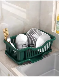Dark green kitchen dish drying rack with drain tray shown on a countertop with dishes