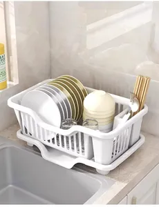 Detailed view of white plastic dish drying rack with organized plates and bowls in kitchen