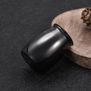 Elegante urna de cremación negra brillante para cenizas sobre una base de madera rústica