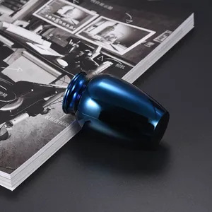 Small polished blue metallic memorial cremation urn for pet or human ashes on dark background