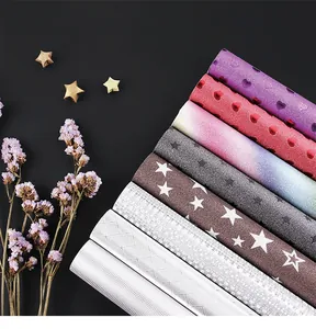 Close-up of assorted glittery and metallic specialty wrapping paper rolls with patterns